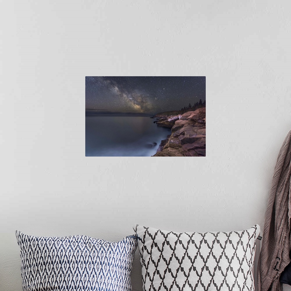 A bohemian room featuring A photograph of a rocky coastline under a starry night sky.