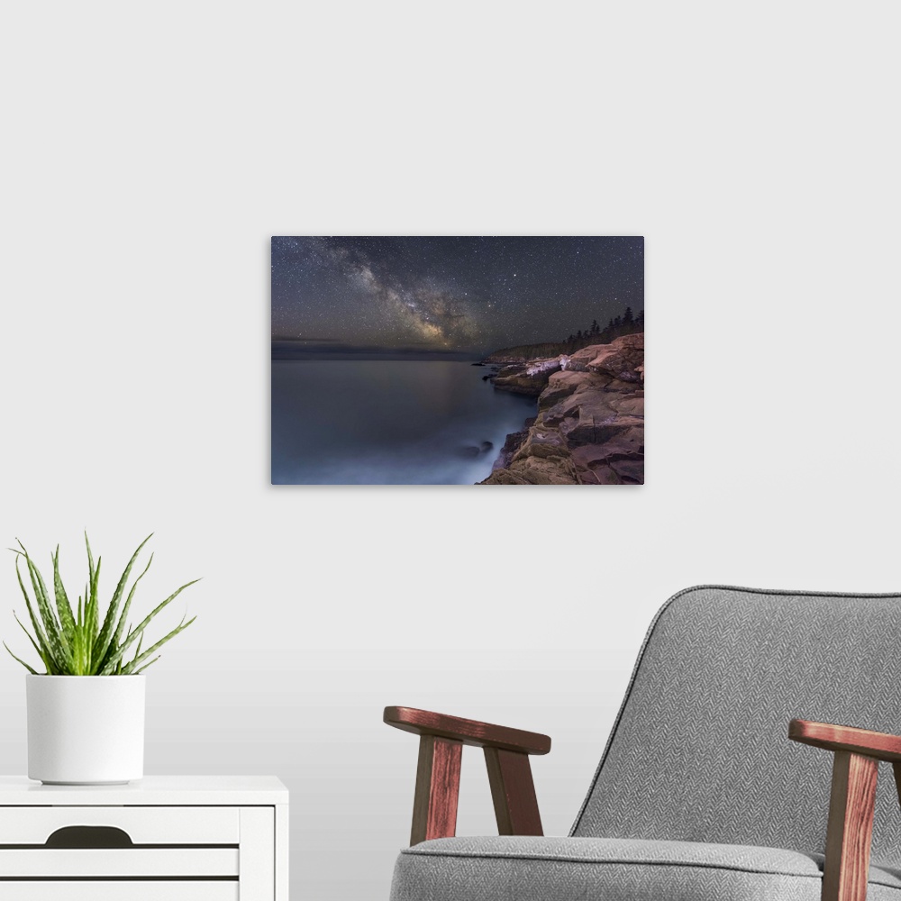 A modern room featuring A photograph of a rocky coastline under a starry night sky.