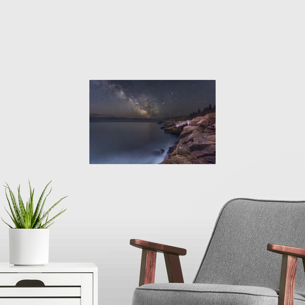 A modern room featuring A photograph of a rocky coastline under a starry night sky.