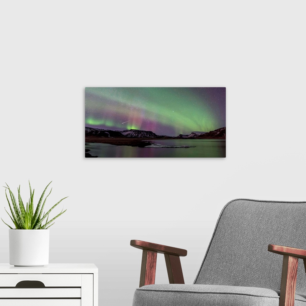 A modern room featuring Long exposure photograph of the Northern Lights over snow covered mountains and a lake.