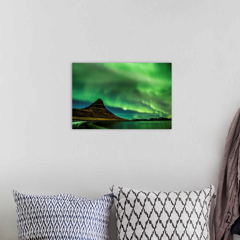 A bohemian room featuring A photograph of an Icelandic landscape with a mountain peak seen under the northern lights illumi...