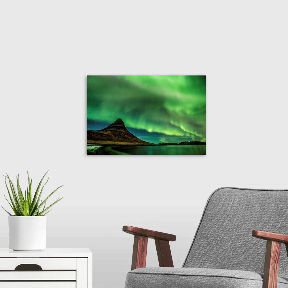 A modern room featuring A photograph of an Icelandic landscape with a mountain peak seen under the northern lights illumi...
