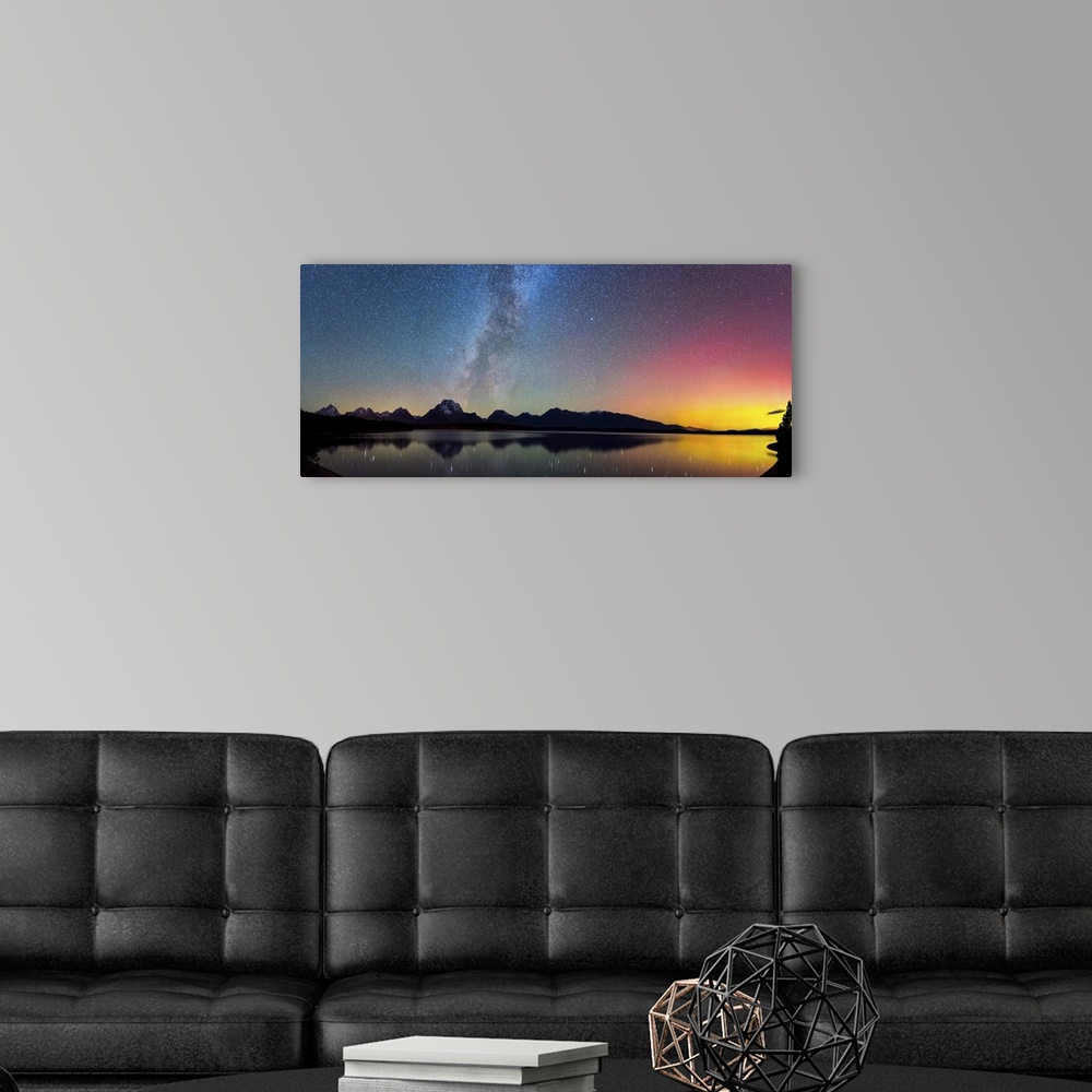 A modern room featuring Aurora Borealis and the Milky Way visible in the sky over a lake.