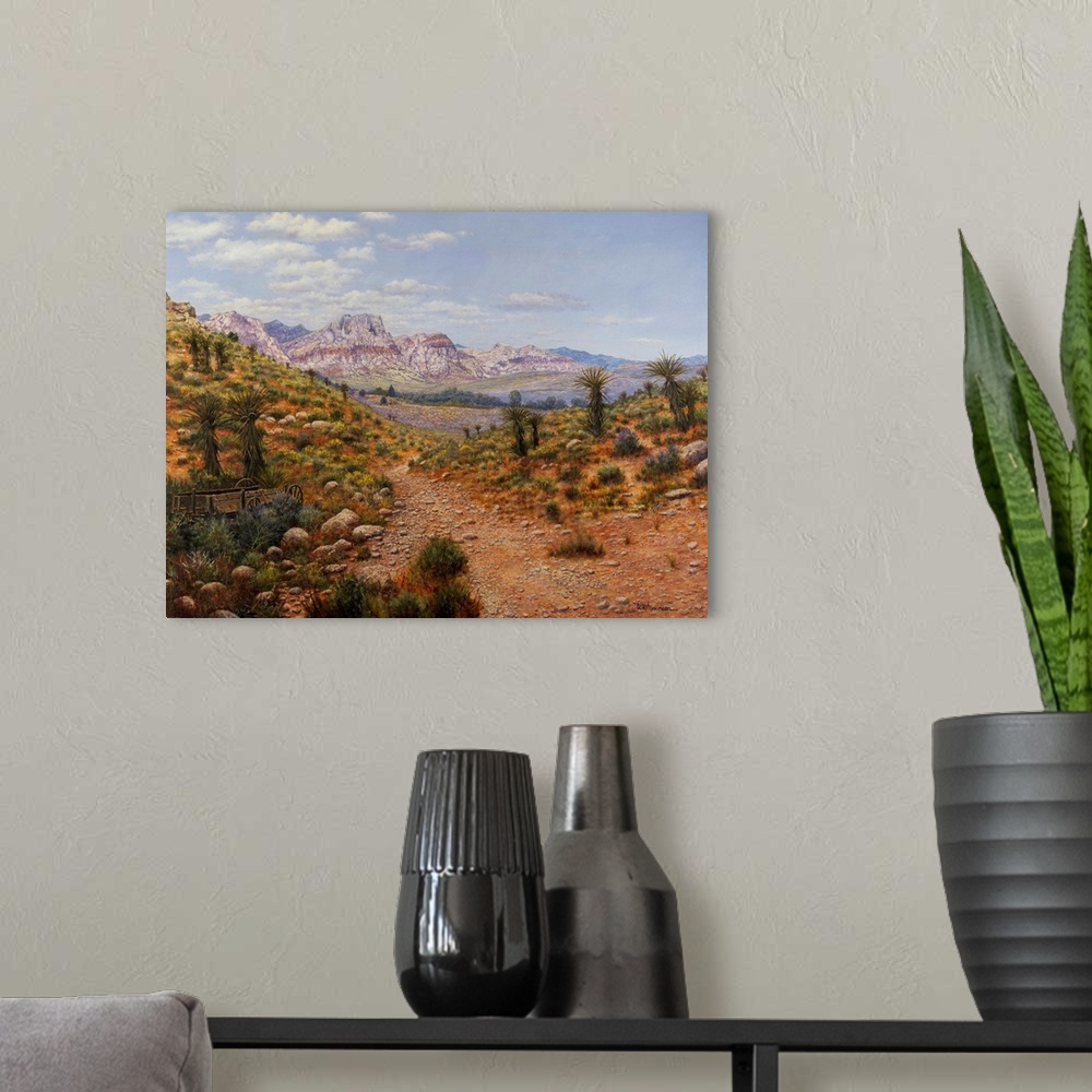 A modern room featuring Dirt trail through arid land with canyons and water in distance.