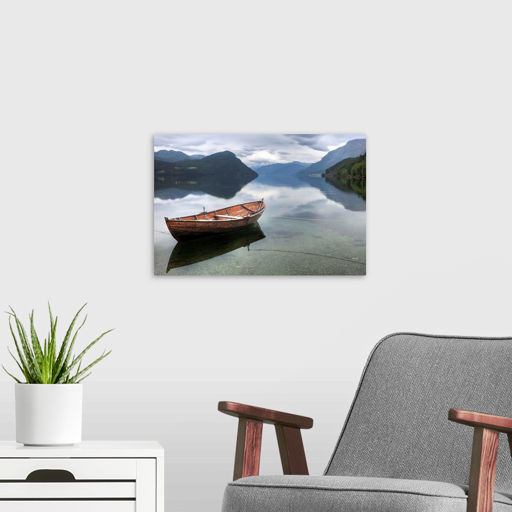 A modern room featuring Red rowing boat on a still lake, Norway