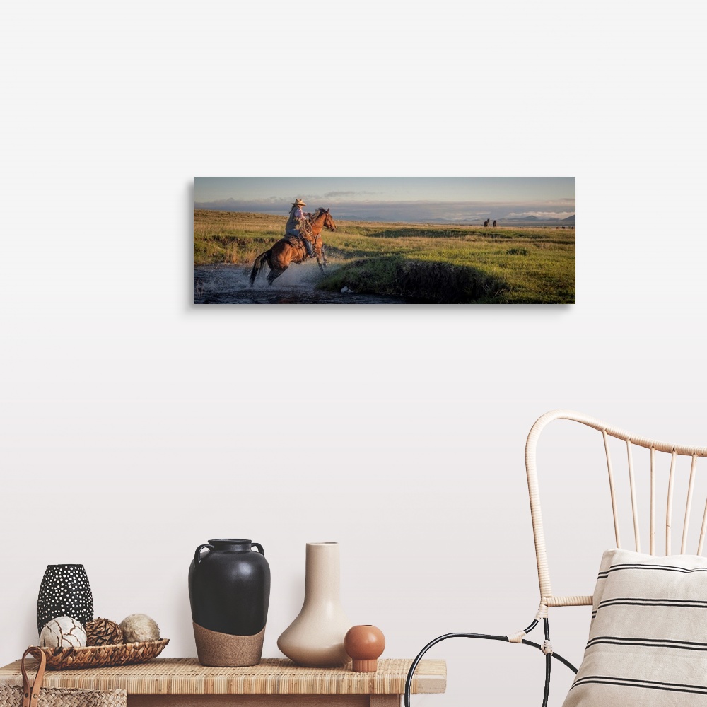 A farmhouse room featuring Action photograph of a cowgirl crossing a river on horseback.