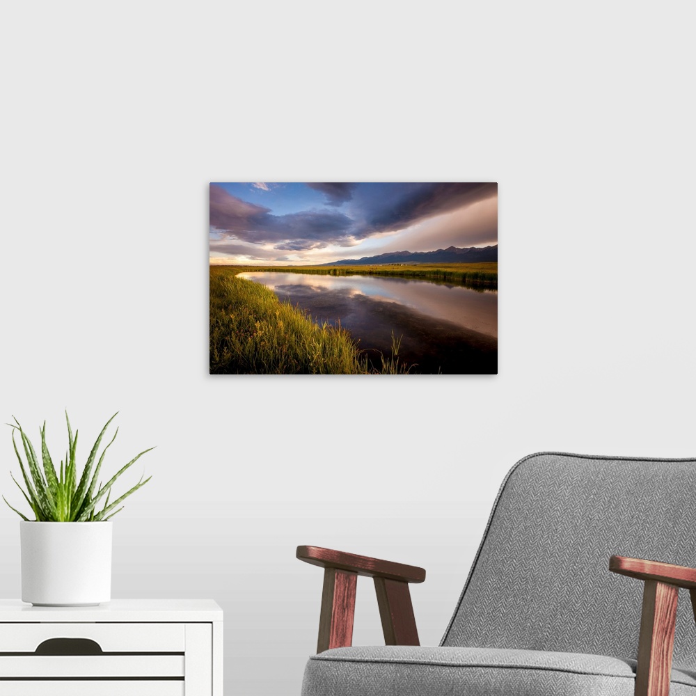 A modern room featuring Landscape photograph of a river in the valley reflecting the cloudy sky.