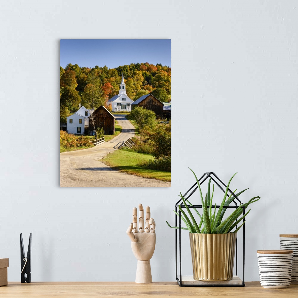 A bohemian room featuring Photograph of a gravel road leading up the hill to a white church surrounded by various wooden bu...