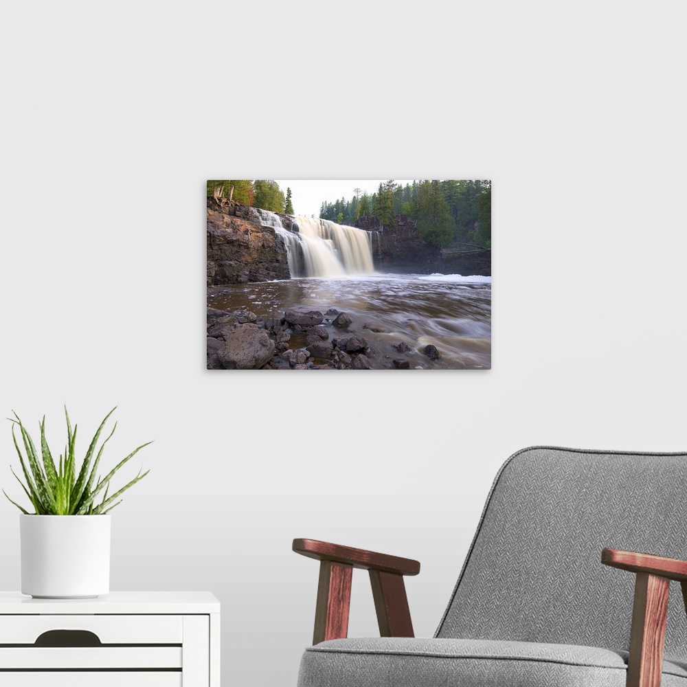 A modern room featuring Photograph of a waterfall caught in motion blur surrounded by forest.