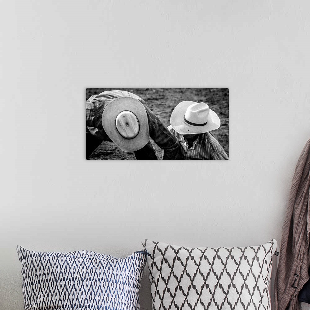 A bohemian room featuring Black and white photograph of two people wearing cowboy hats on the ground at a rodeo.