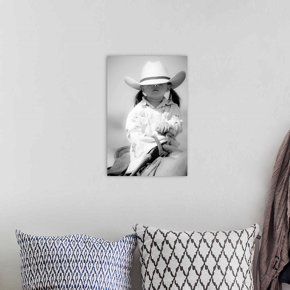 A bohemian room featuring Black and white portrait of a young girl with a cowboy hat covering her eyes on horseback.