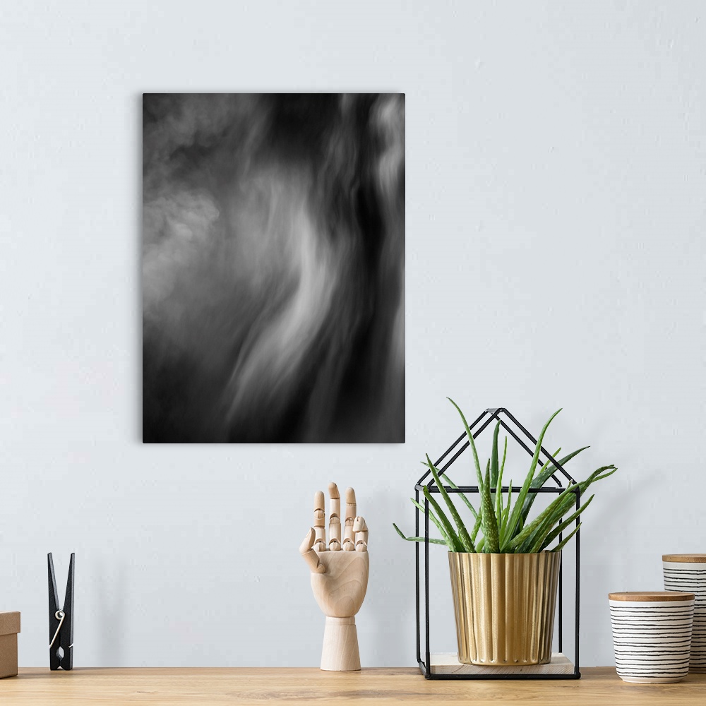 A bohemian room featuring Black and white smokey abstract photograph.