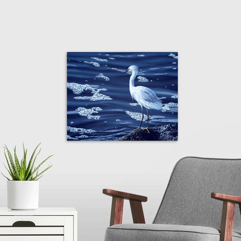 A modern room featuring A snowy egret rests on a rock near the water's edge.