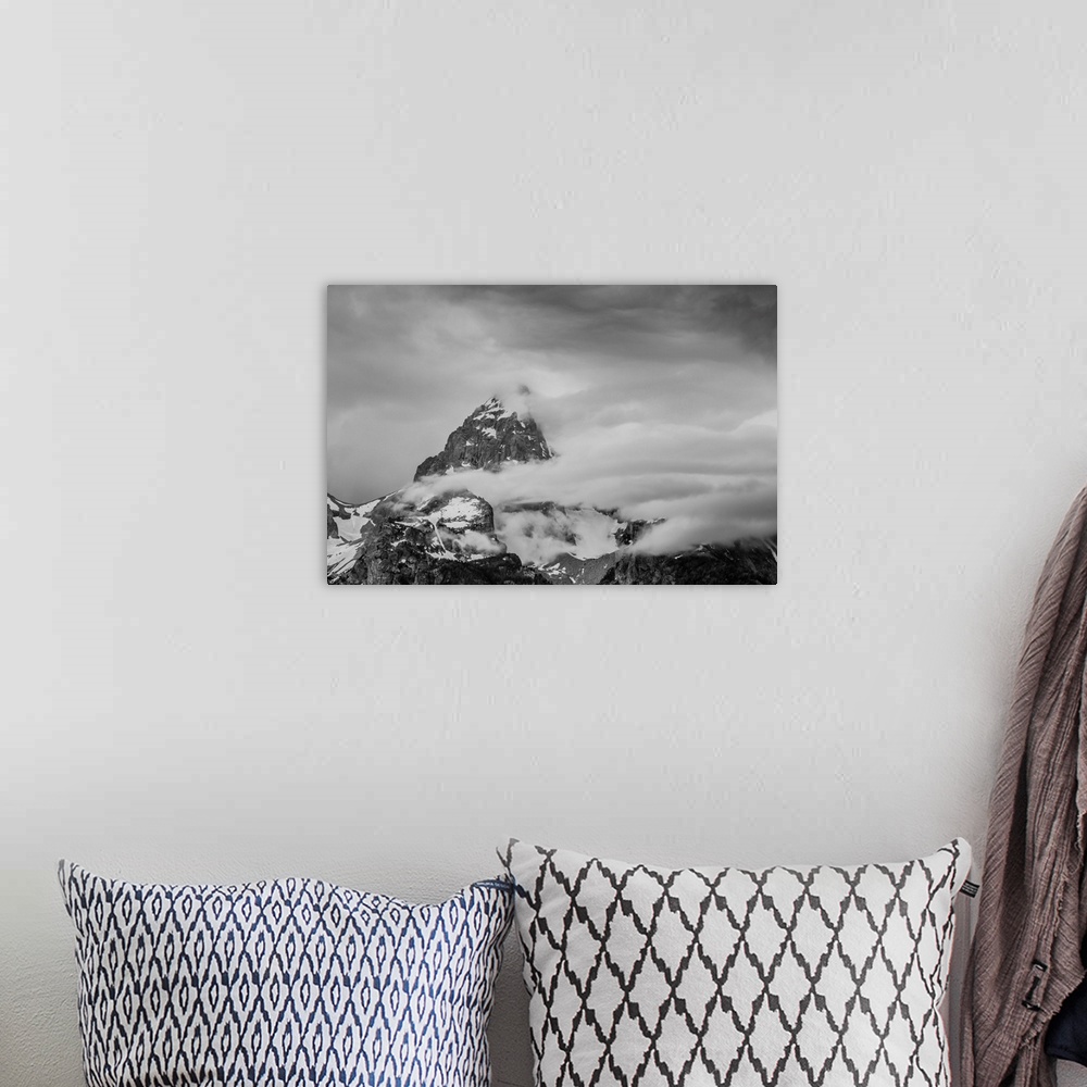 A bohemian room featuring Black and white photograph of a cloudy mountain peak.
