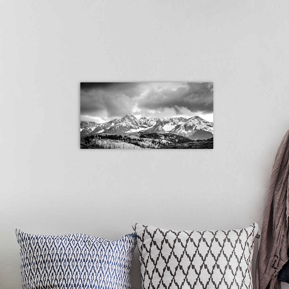 A bohemian room featuring Black and white landscape photograph of snowy mountains under a cloudy sky.