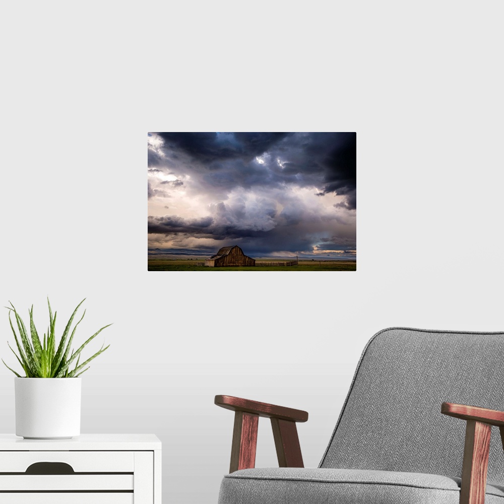 A modern room featuring A photograph of a farm landscape under the dark clouds of an incoming storm.