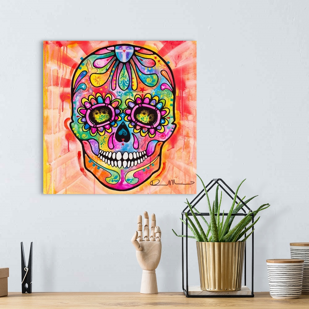 A bohemian room featuring Bright painting of a skull for Dia de los Muertos with paint dripping in the background.