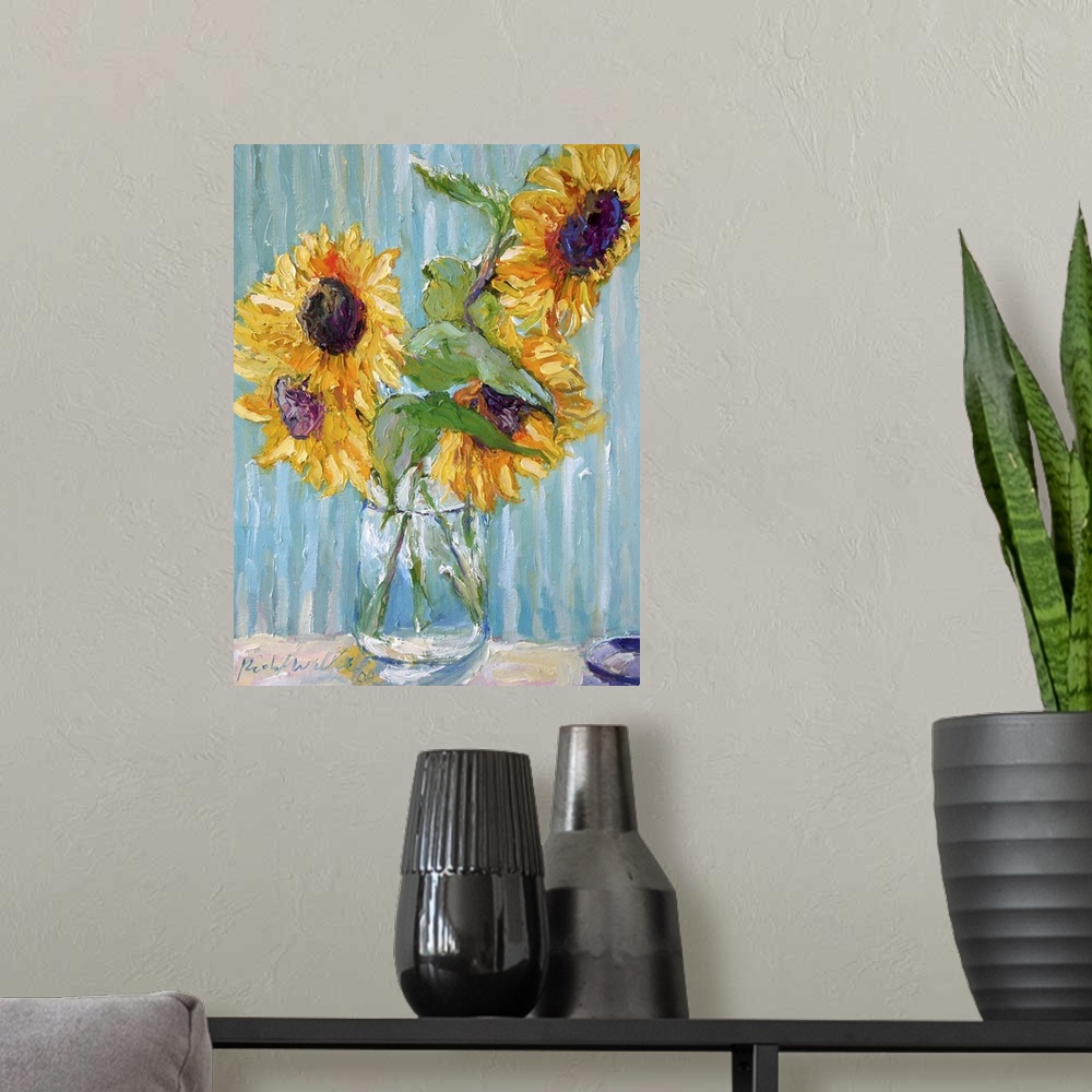 A modern room featuring Sunflowers in a clear glass vase.