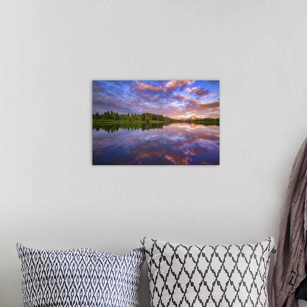 A bohemian room featuring Vibrant clouds over a lake at dawn.