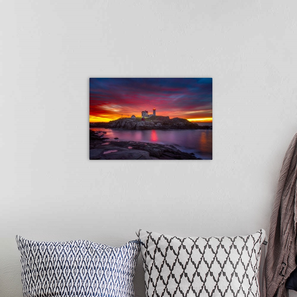 A bohemian room featuring A vibrant sunset over Cape Neddick Lighthouse in York, Maine.