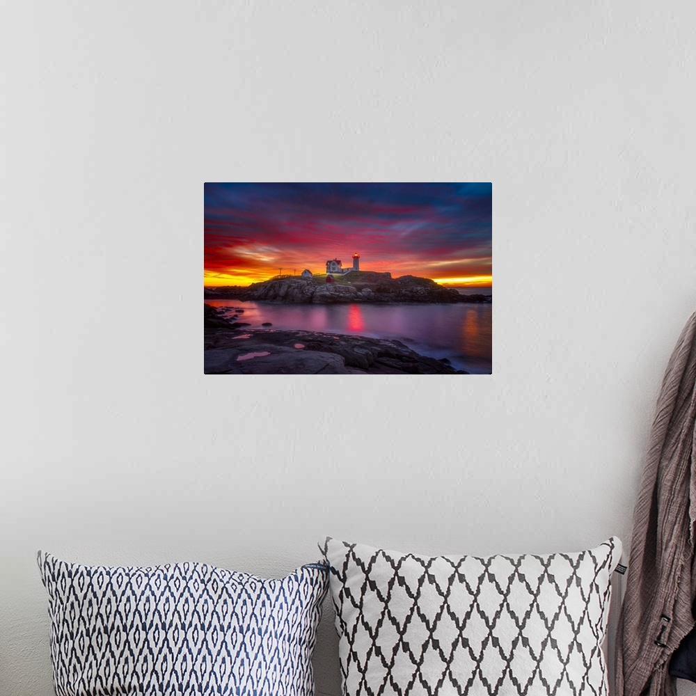 A bohemian room featuring A vibrant sunset over Cape Neddick Lighthouse in York, Maine.