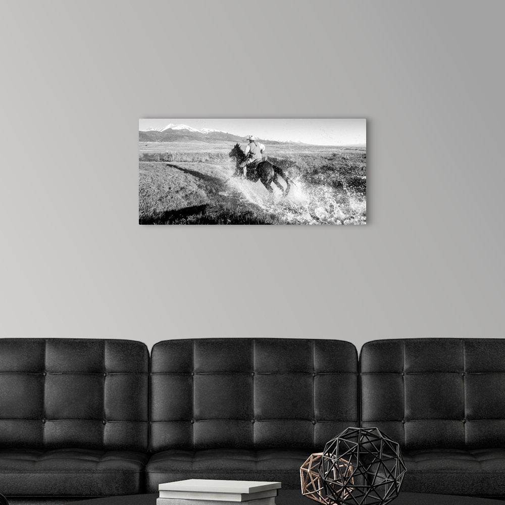 A modern room featuring Action photograph of a cowgirl splashing across a river on horseback with snow capped mountains i...