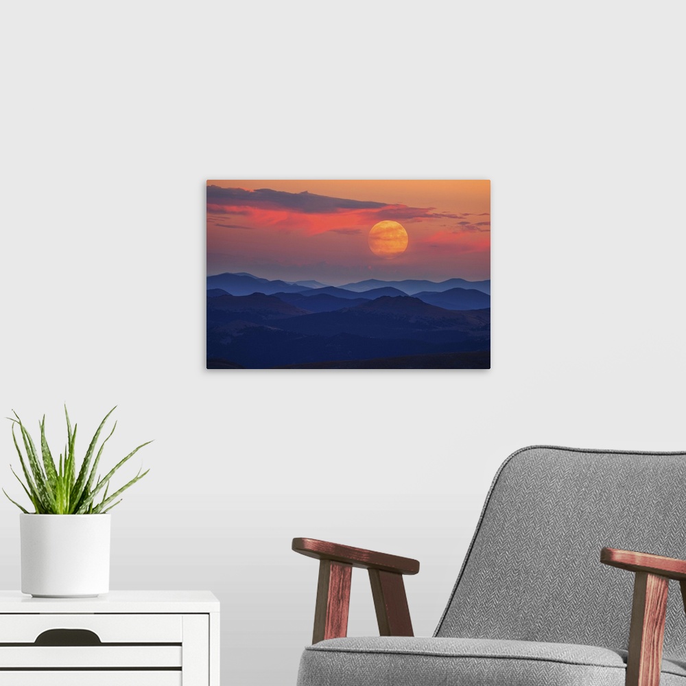 A modern room featuring A glowing moon at dawn over misty mountains.