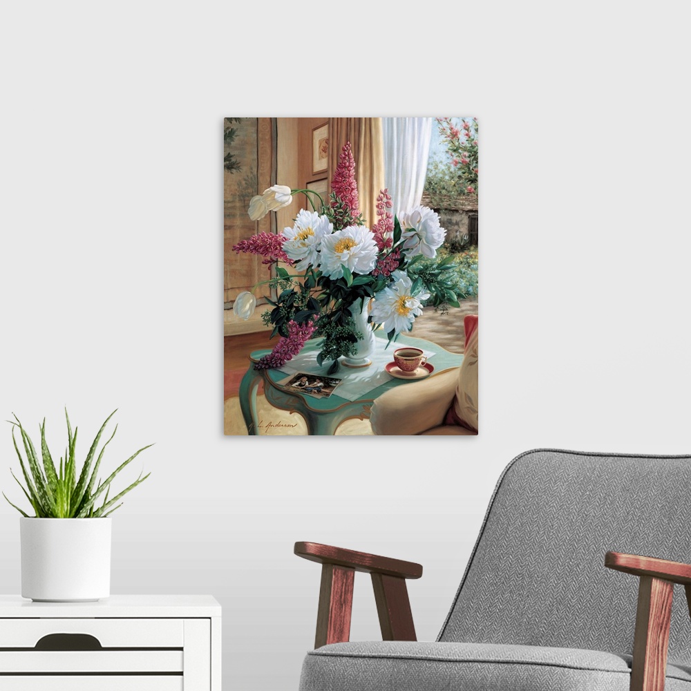 A modern room featuring Bouquet of Peonies, French Tulips and delphiniums in a vase on a table with coffee cup by a window.
