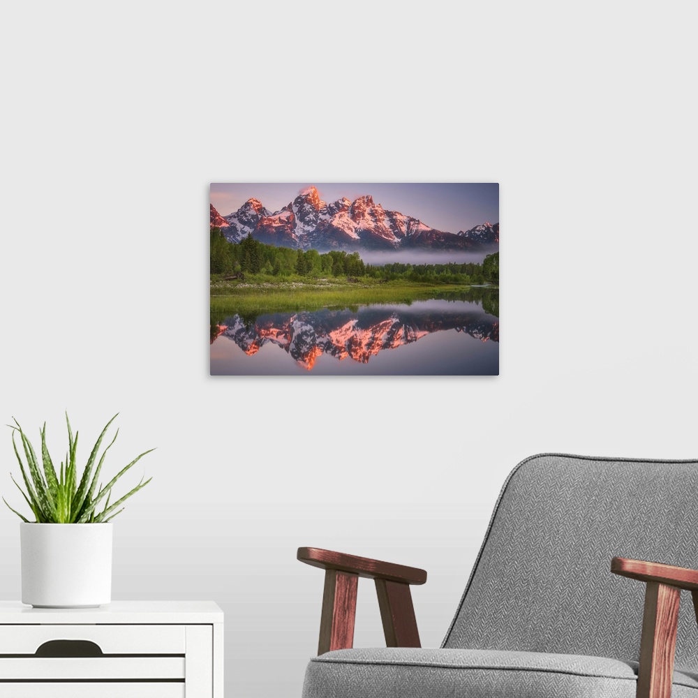 A modern room featuring Bright sunlight on the peaks of the Grand Teton mountains.