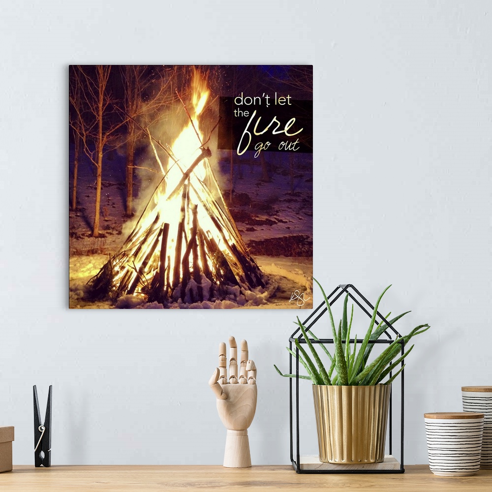 A bohemian room featuring Motivational text against background photograph of a giant campfire.