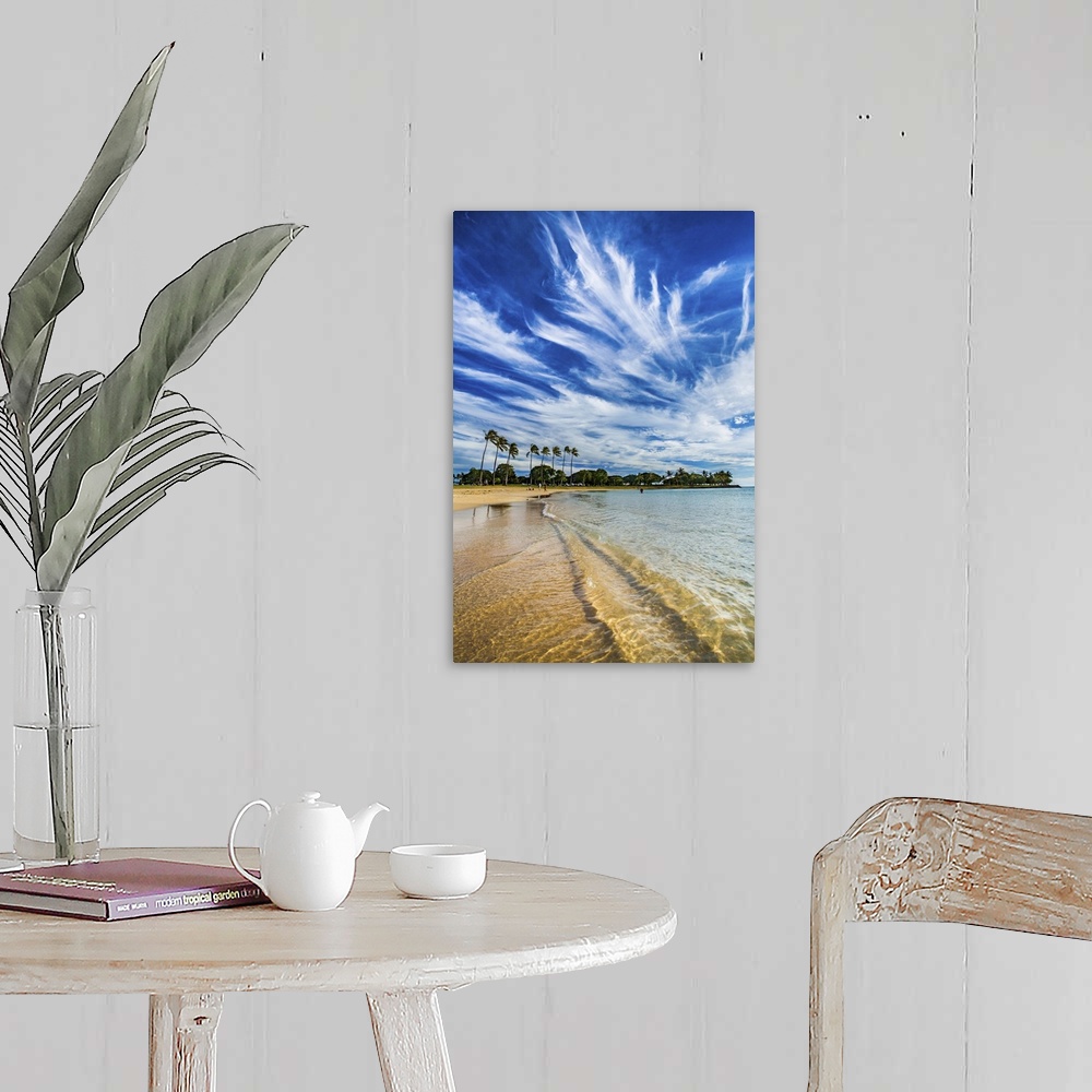 A farmhouse room featuring A photograph of long wispy clouds over a tropical Hawaiian beach.
