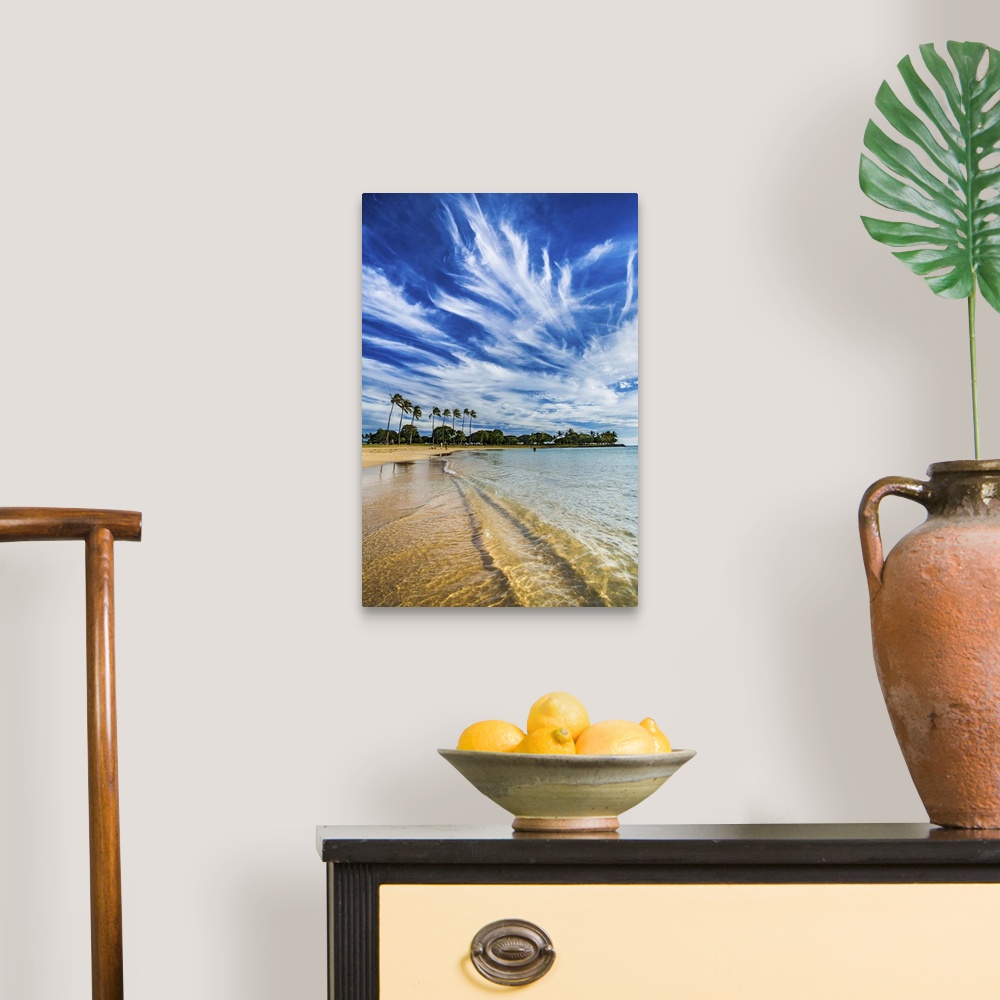 A traditional room featuring A photograph of long wispy clouds over a tropical Hawaiian beach.