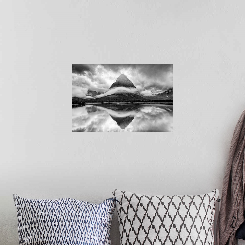 A bohemian room featuring A black and white photograph of a pointed mountain surrounded by a ribbon of cloud while casting ...