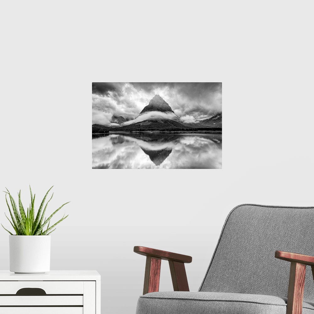 A modern room featuring A black and white photograph of a pointed mountain surrounded by a ribbon of cloud while casting ...