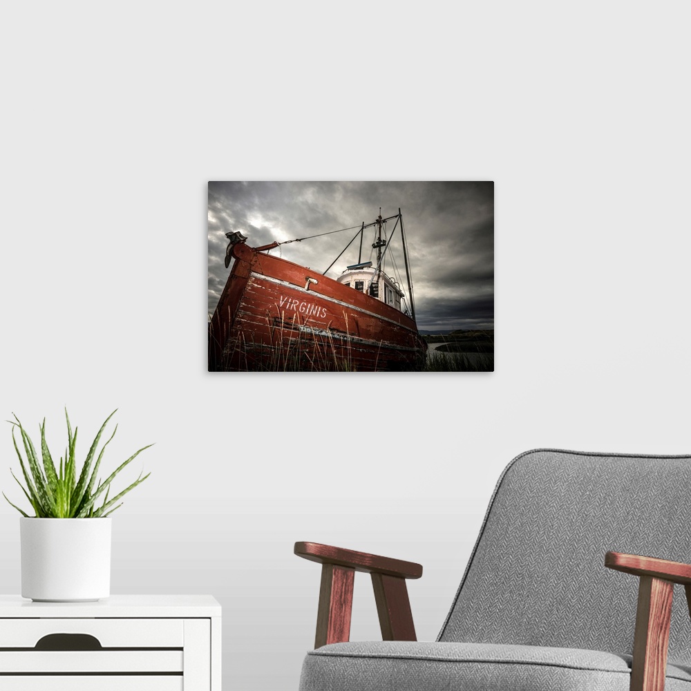 A modern room featuring Photograph of an old red boat called "Virginis" pulled up on the shore on a dark overcast day.