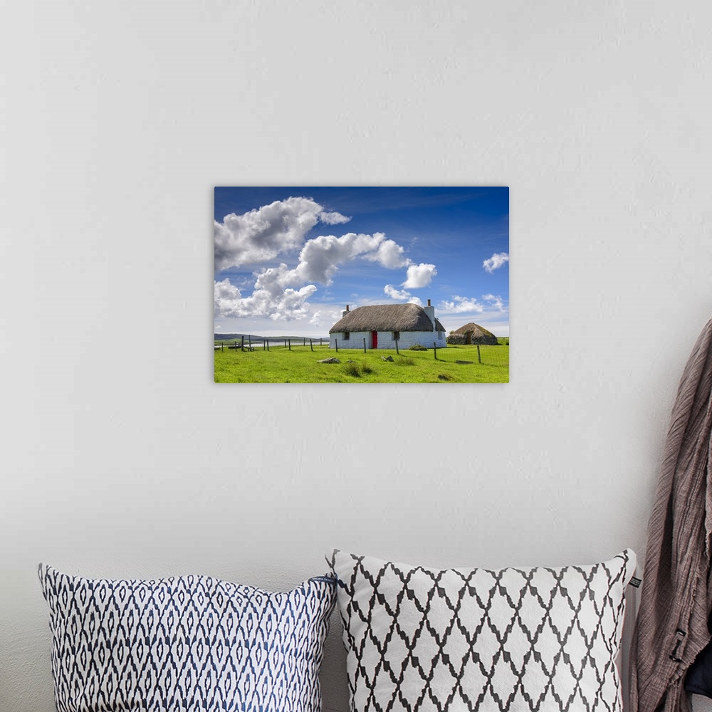 A bohemian room featuring Beautiful photograph of a white house with a red door in the countryside with white fluffy clouds...
