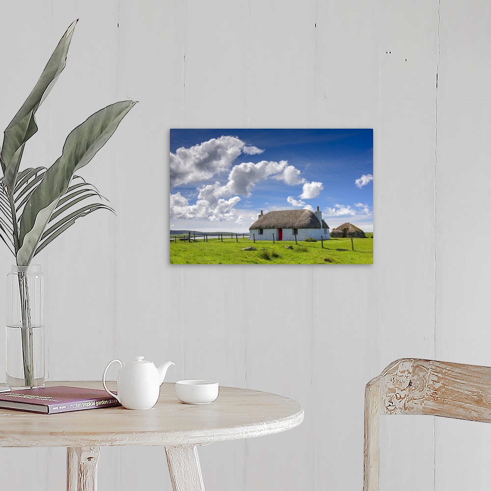 A farmhouse room featuring Beautiful photograph of a white house with a red door in the countryside with white fluffy clouds...