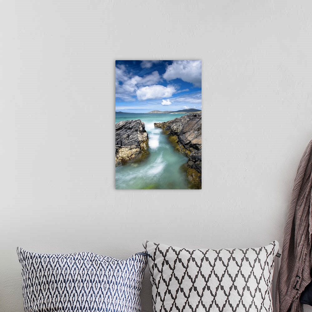 A bohemian room featuring Landscape photograph of crystal blue waters rushing though a gap between rocky cliffs.