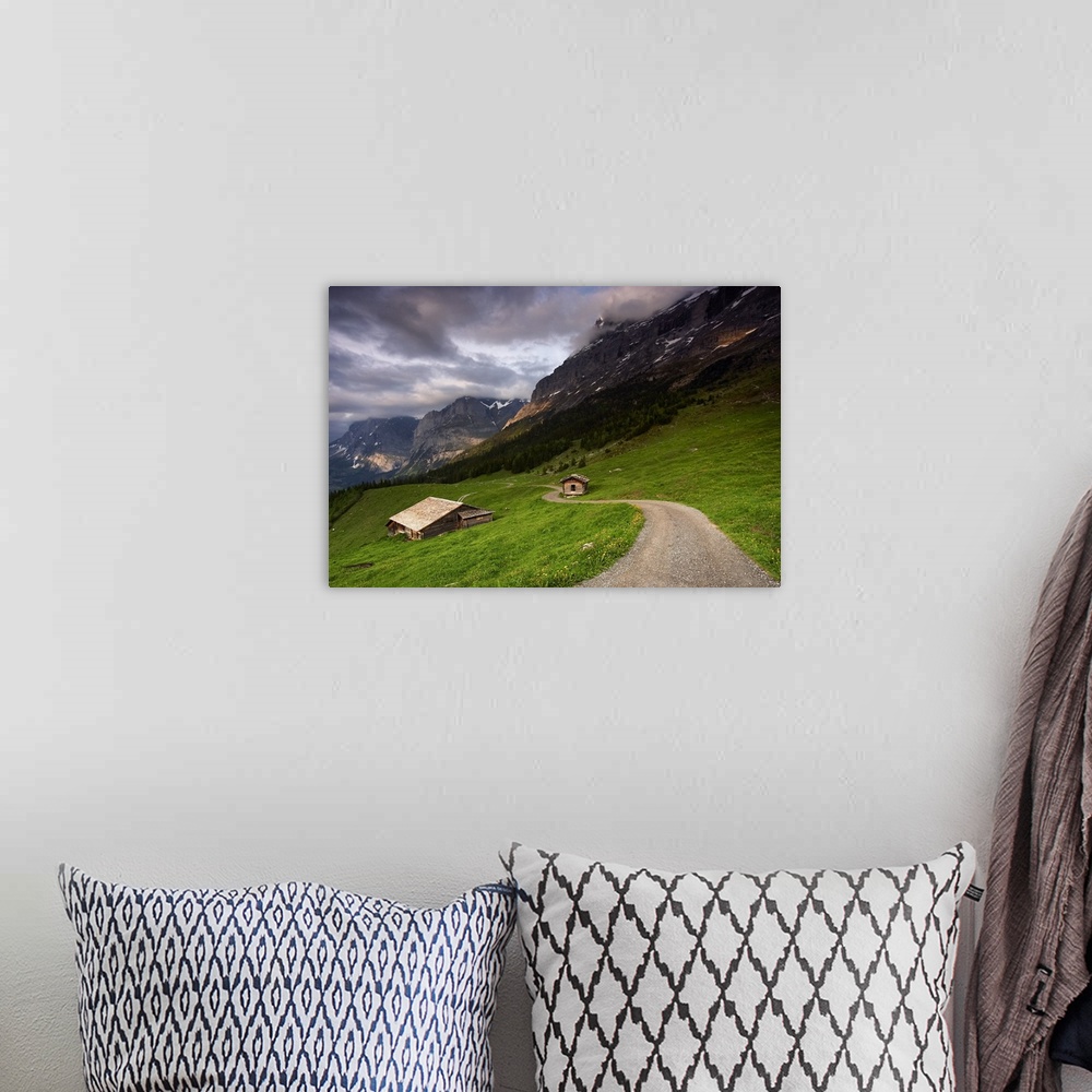 A bohemian room featuring A photograph of the roof of a cottage in a dreary mountainous valley landscape.