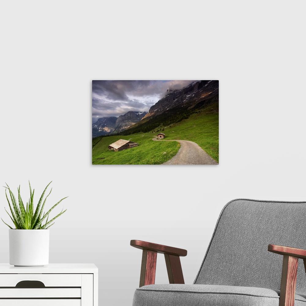 A modern room featuring A photograph of the roof of a cottage in a dreary mountainous valley landscape.