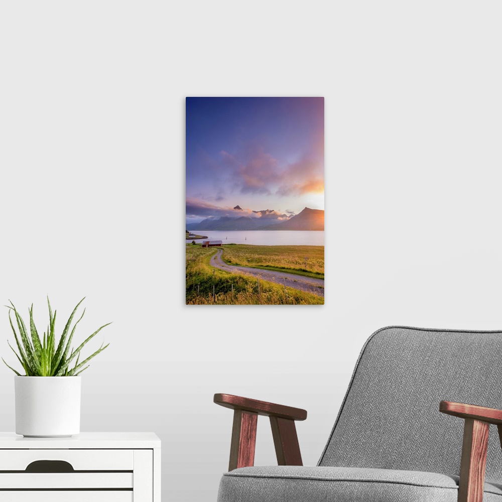 A modern room featuring Photograph of a gravel road leading to a red barn in front of a lake with mountains in the backgr...
