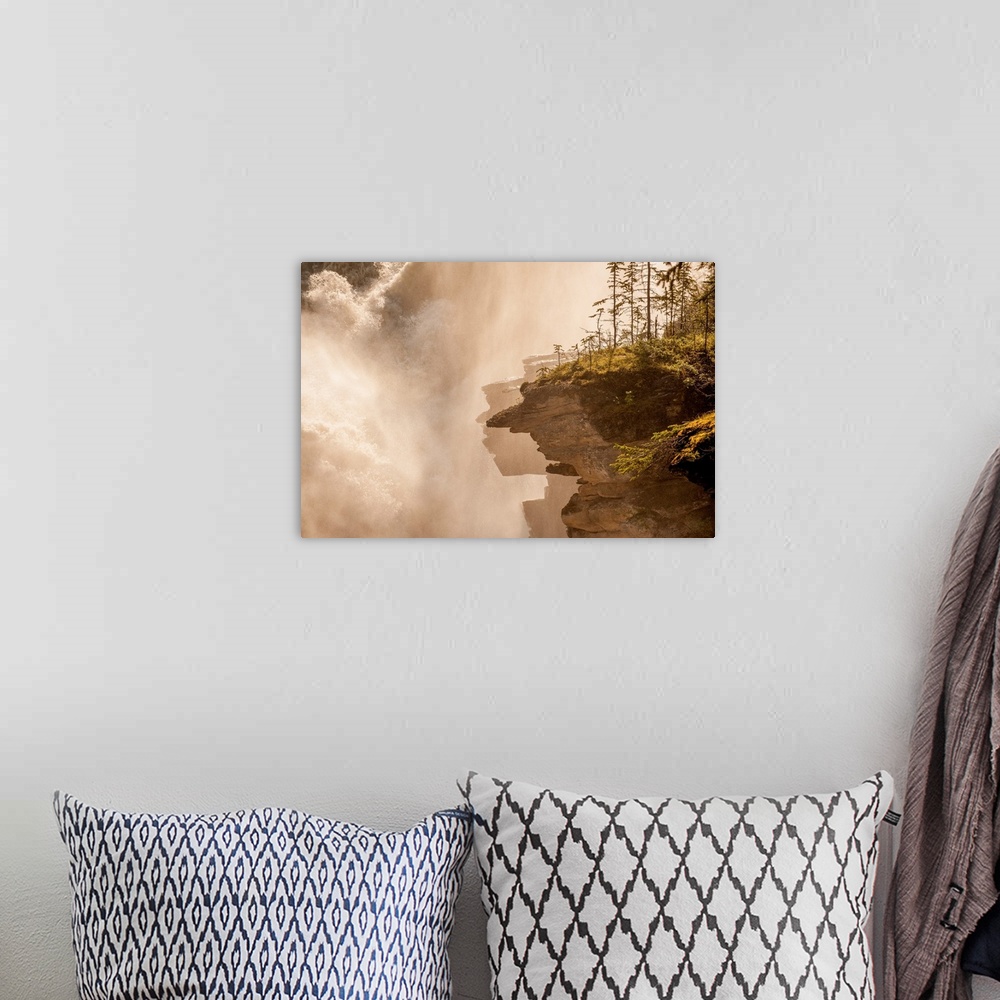 A bohemian room featuring Misty photograph of rocky cliffs next to a large, rushing waterfall.