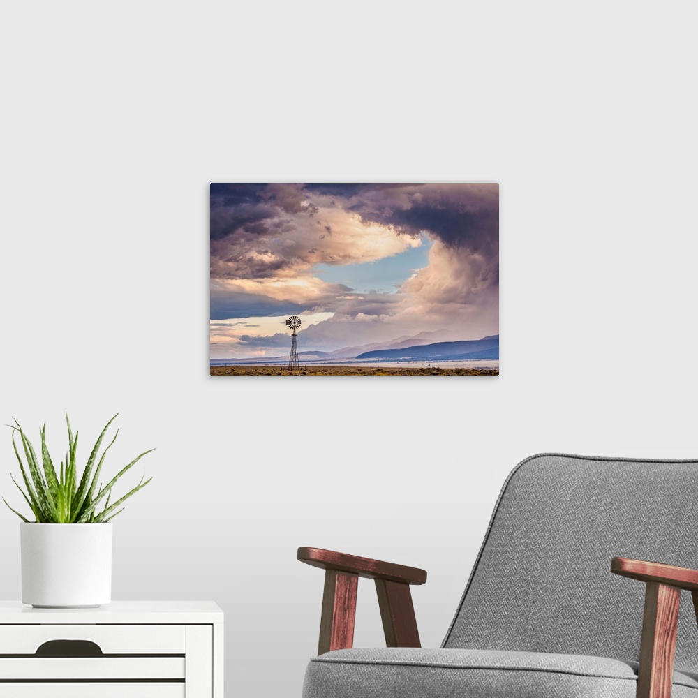 A modern room featuring Landscape photograph of a windmill in a field with a mountain range in the background and a drama...