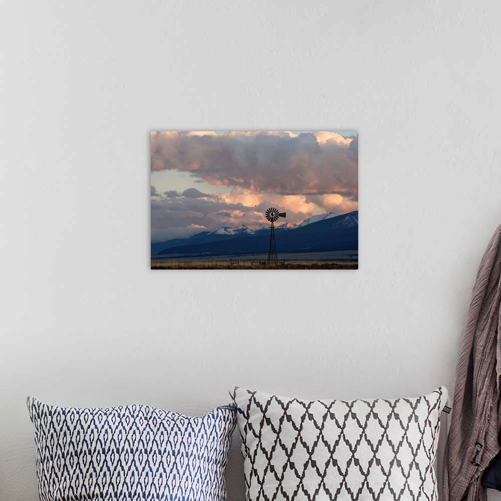 A bohemian room featuring Landscape photograph of a windmill in a field with snow covered mountain peaks in the distance.