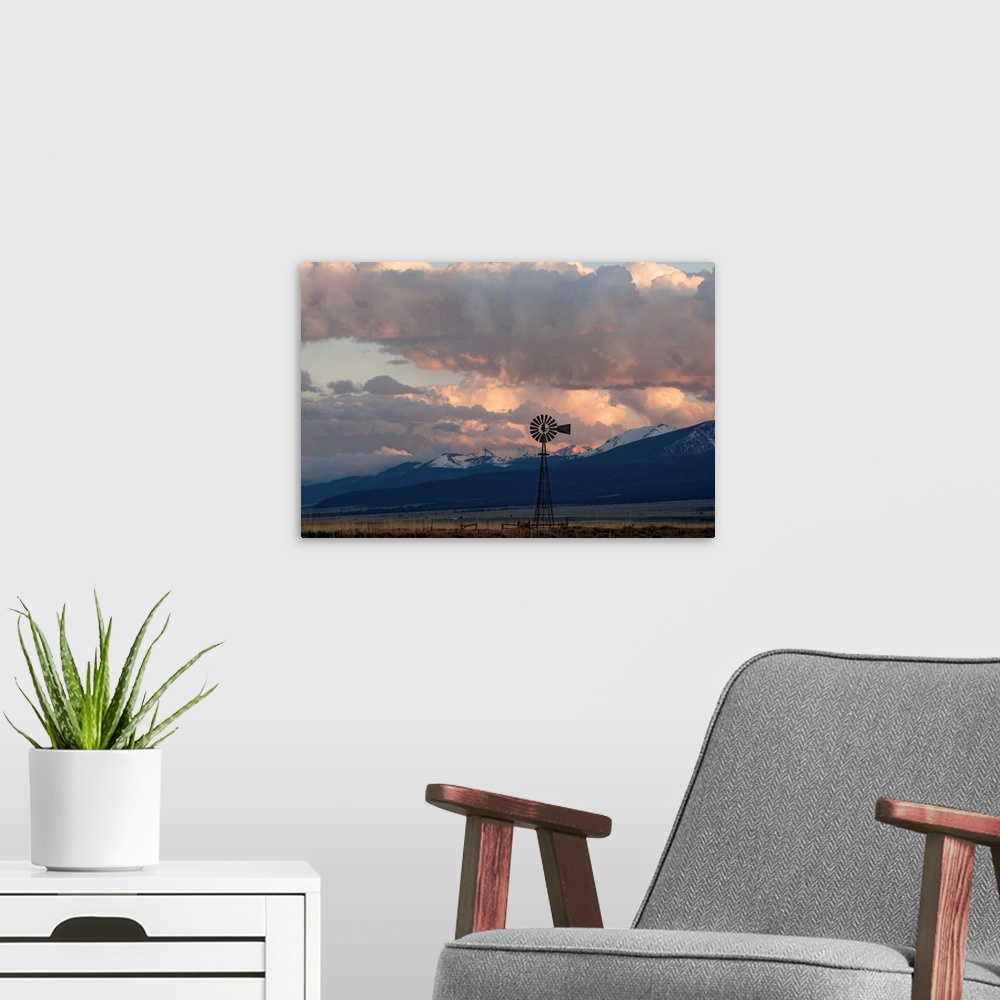 A modern room featuring Landscape photograph of a windmill in a field with snow covered mountain peaks in the distance.