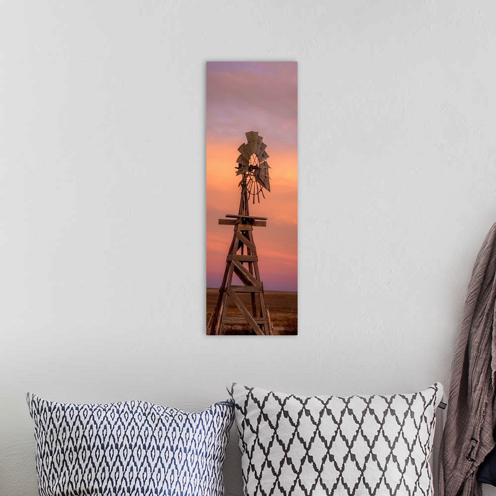 A bohemian room featuring Tall photograph of a wooden windmill at sunset.