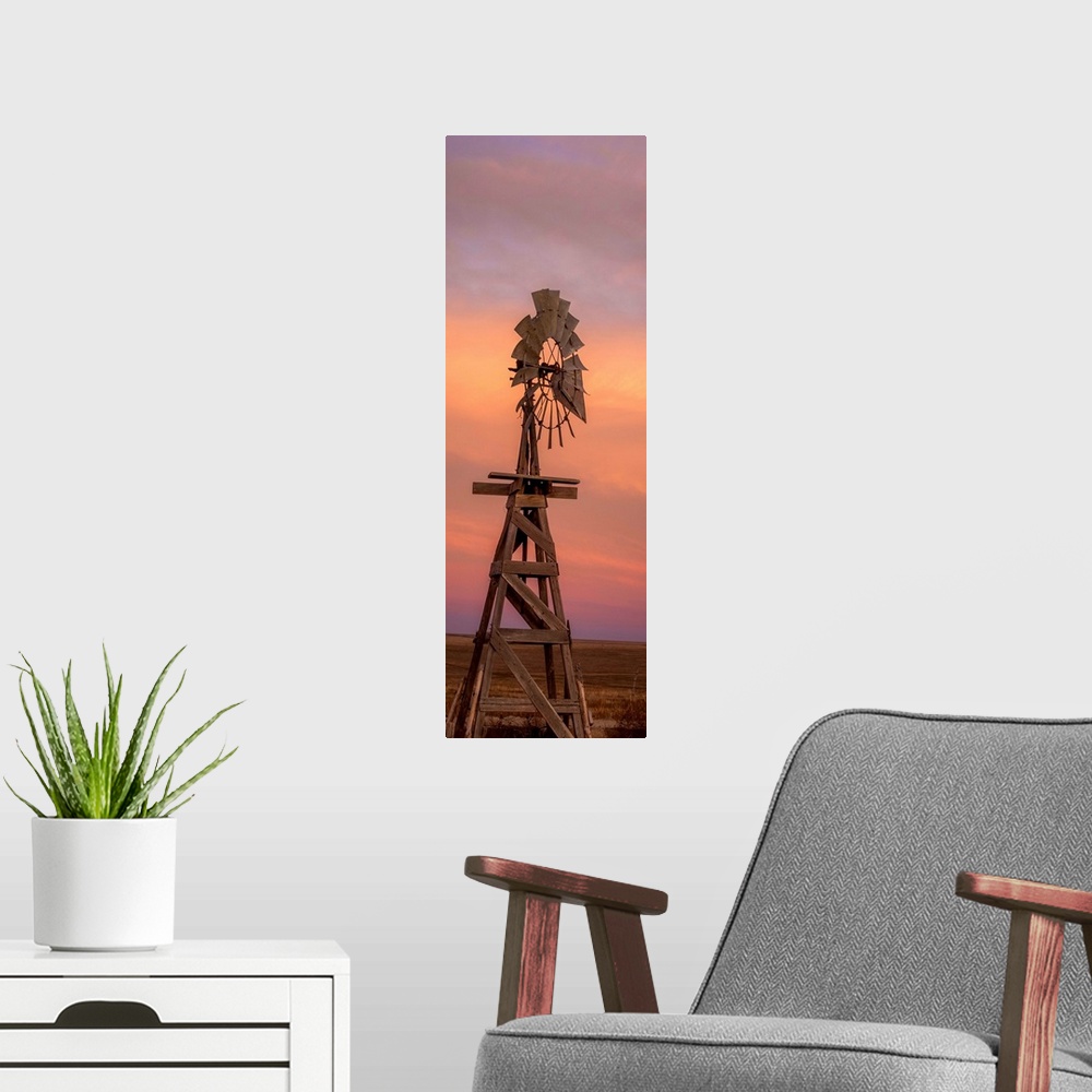 A modern room featuring Tall photograph of a wooden windmill at sunset.