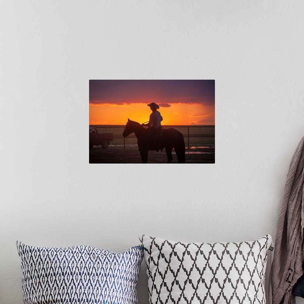 A bohemian room featuring Silhouette photograph of a cowboy on horseback with a beautiful purple and orange sunset in the b...