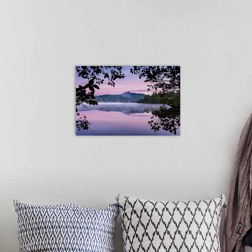 A bohemian room featuring Landscape photograph of a mountain view reflecting onto a foggy lake with a pink and purple sunse...