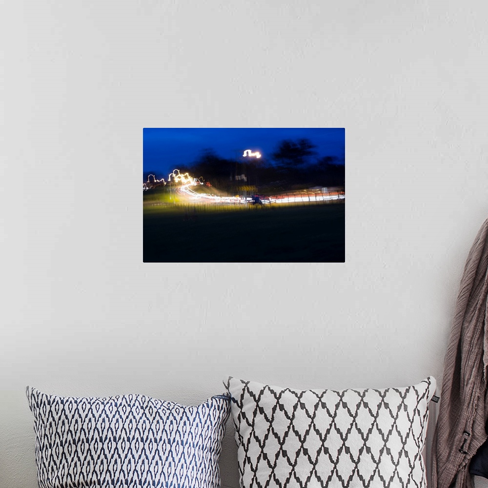 A bohemian room featuring Impressionist photograph of a busy country road at night with cars light painting the road.